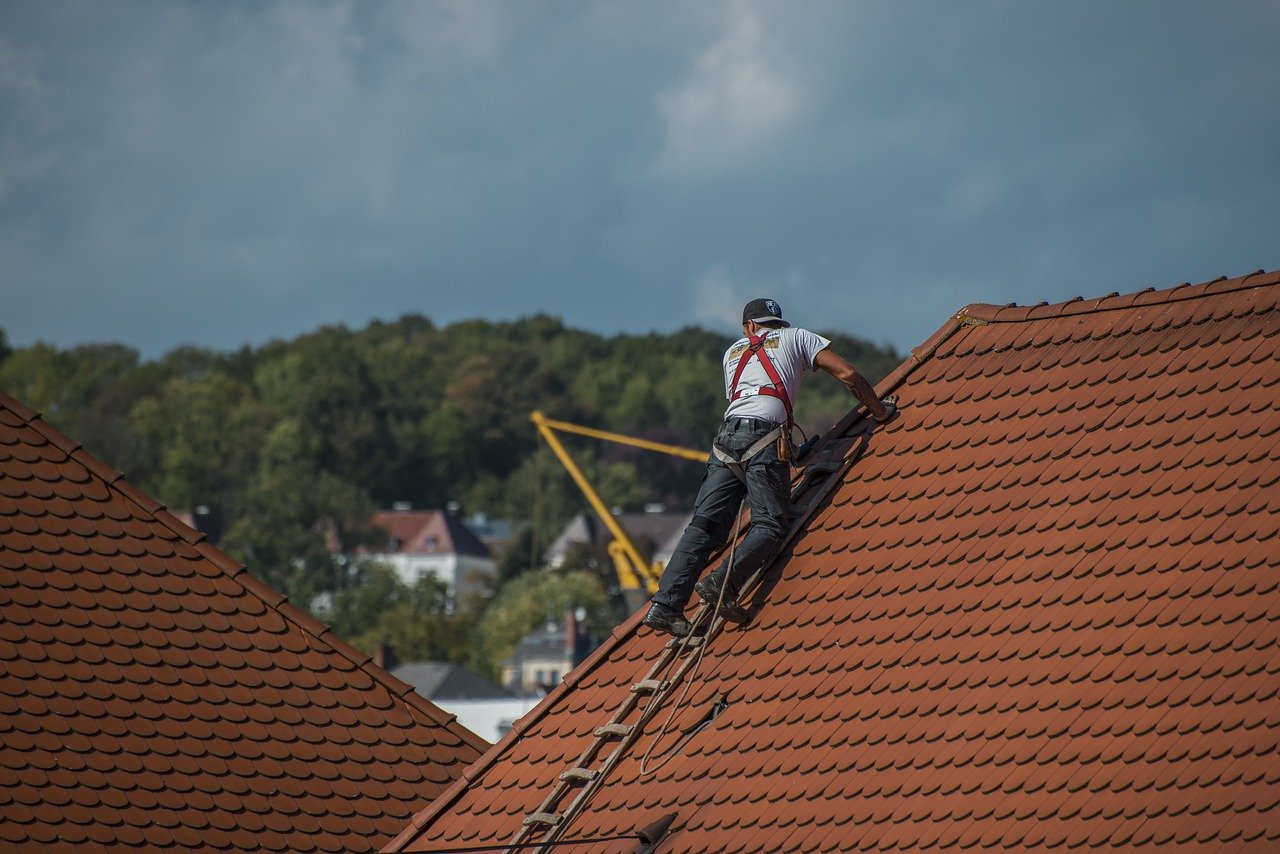 Professional roofers working on a roof showcasing essential website features for roofing businesses.